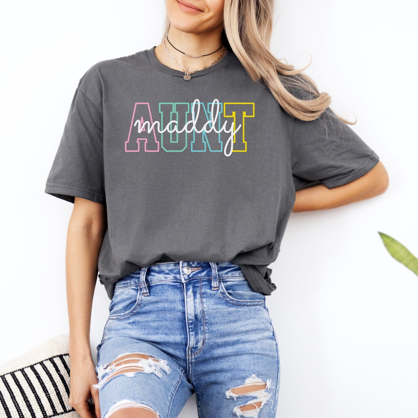 Woman wearing gray Custom Aunt Shirt with multicolor block AUNT letters and white cursive maddy name