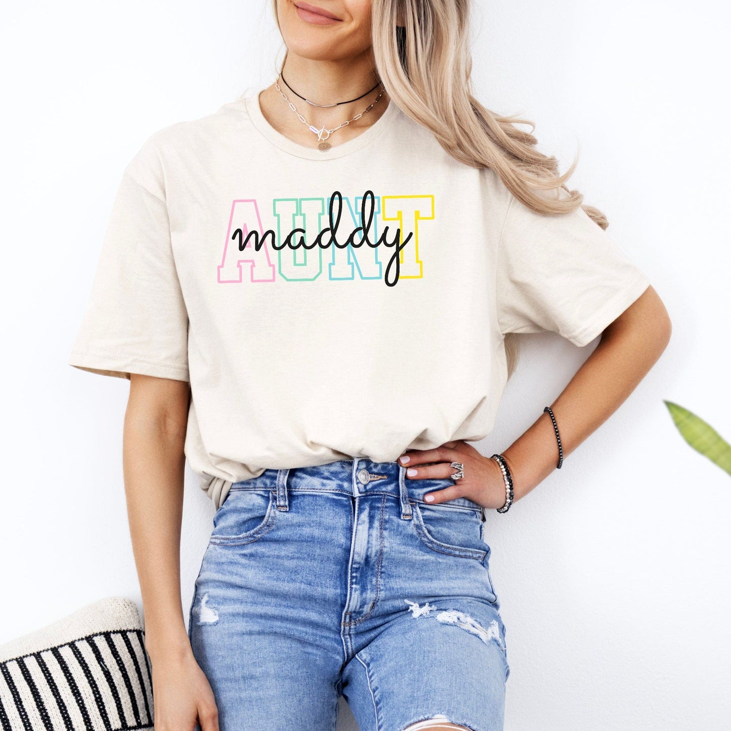 Custom Aunt Shirt beige tee with pastel AUNT letters handwritten maddy script modeled with high waisted ripped jeans