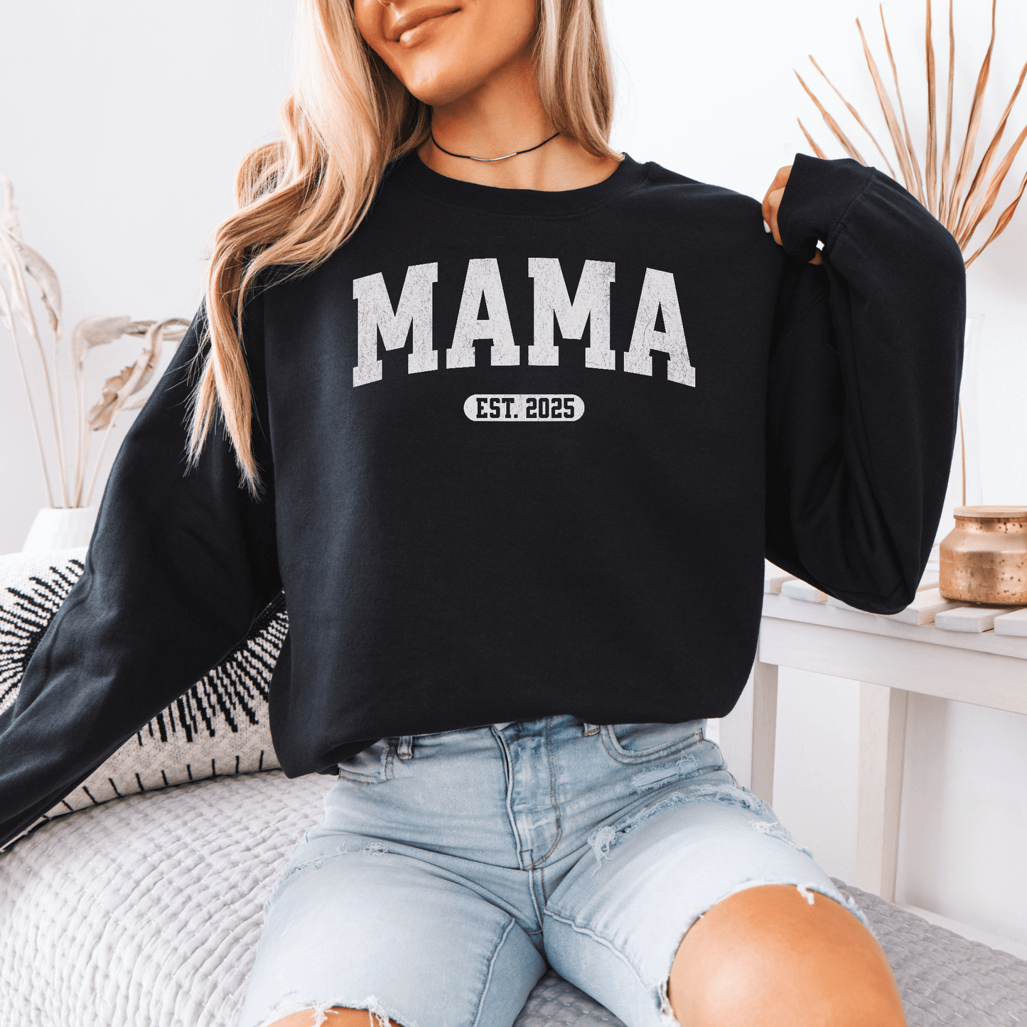 Model wearing black MAMA sweatshirt with white collegiate print and EST 2025 patch Custom Mama EST Year Sweatshirt.