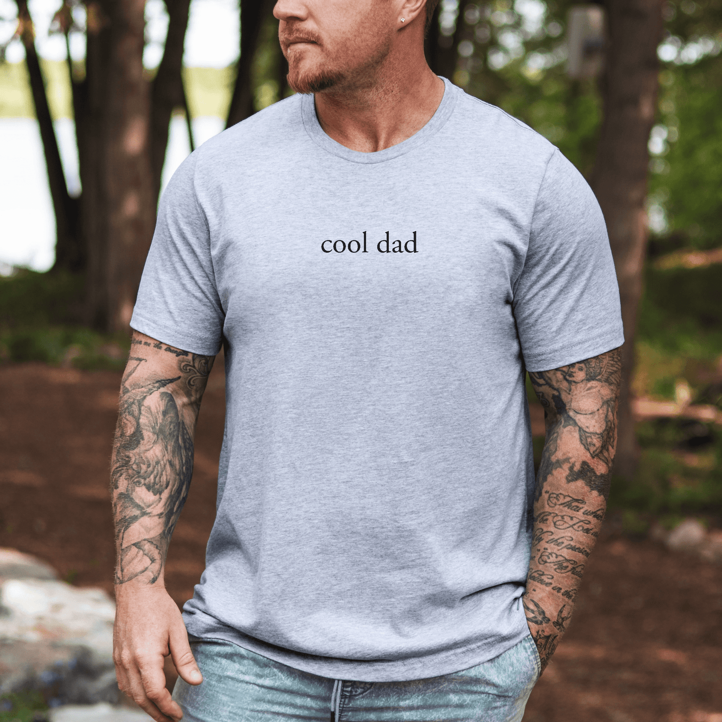 Maddy and George Designs Minimalist Cool Dad Shirt light gray tee worn by tattooed man outdoors