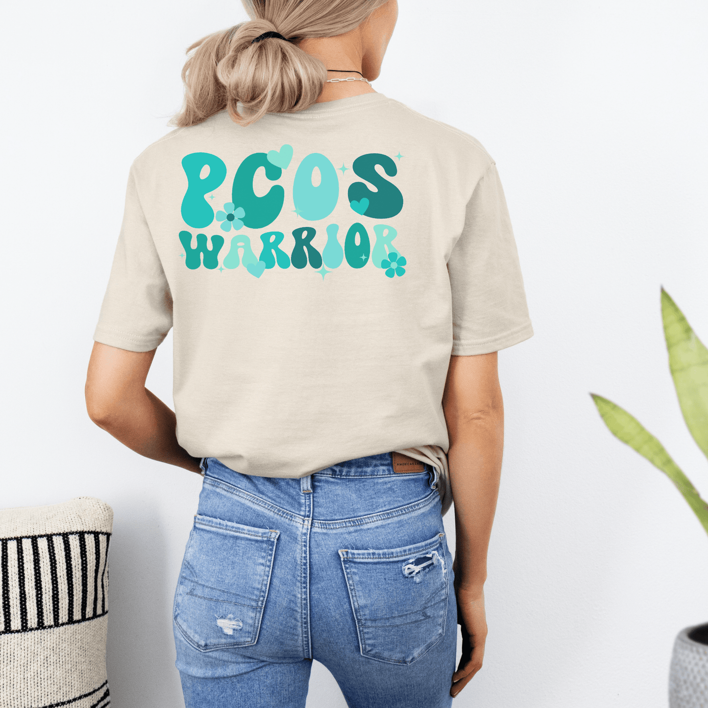 Back view of beige tee with teal PCOS Warrior print Polycystic Ovary Syndrome Awareness Shirt