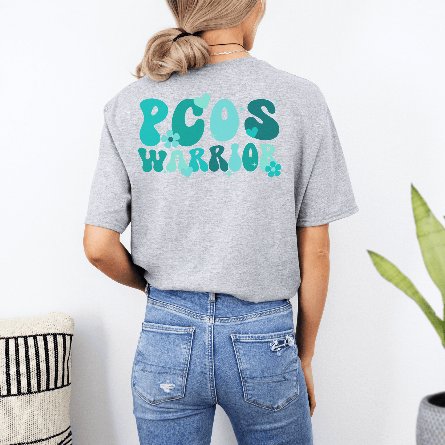 Back view of woman wearing gray tee with teal PCOS Warrior print Polycystic Ovary Syndrome Awareness Shirt