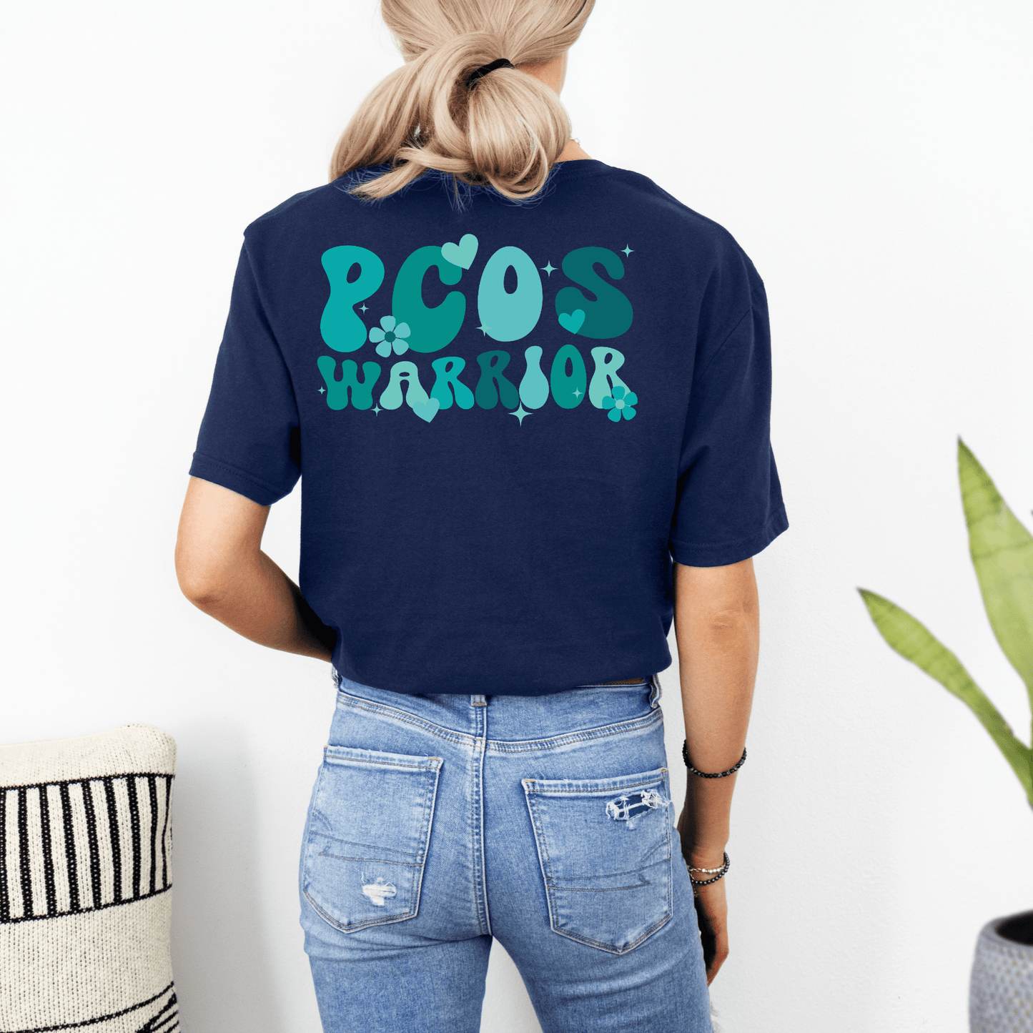 Back view of woman wearing navy tee with teal PCOS WARRIOR print Polycystic Ovary Syndrome Awareness Shirt