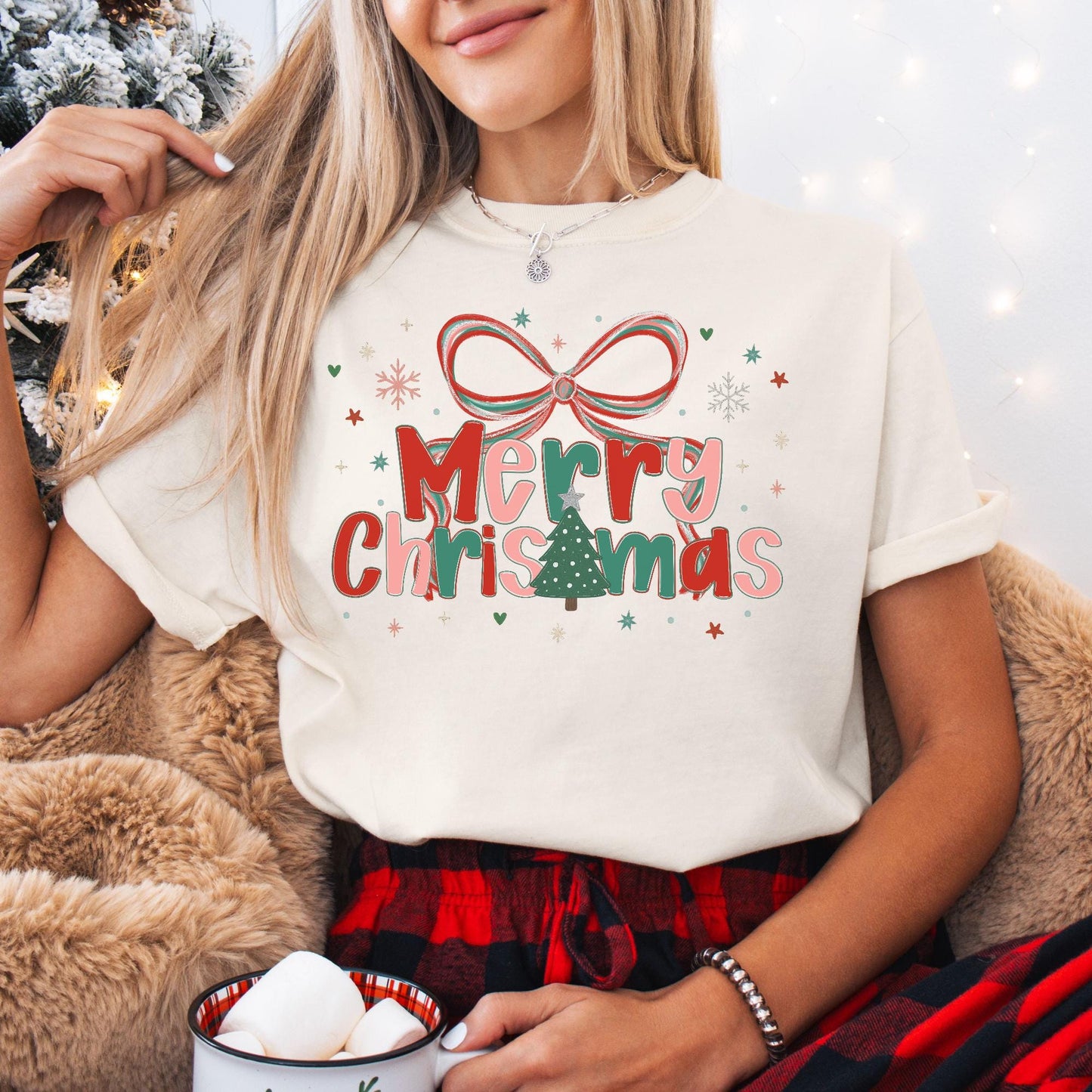 Woman wearing Preppy Merry Christmas Shirt cream tee with bow and Christmas tree graphic