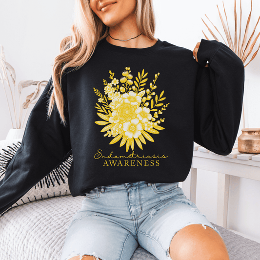 Model wearing Floral Endometriosis Awareness Sweatshirt . Black crewneck with yellow floral bouquet print and awareness text