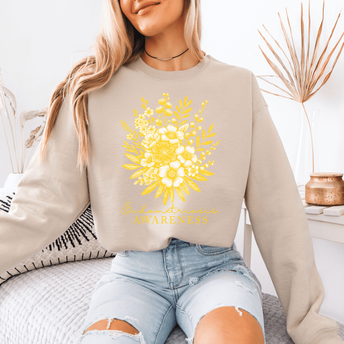 Model wearing Floral Endometriosis Awareness Sweatshirt . Beige crewneck with yellow floral bouquet and awareness script