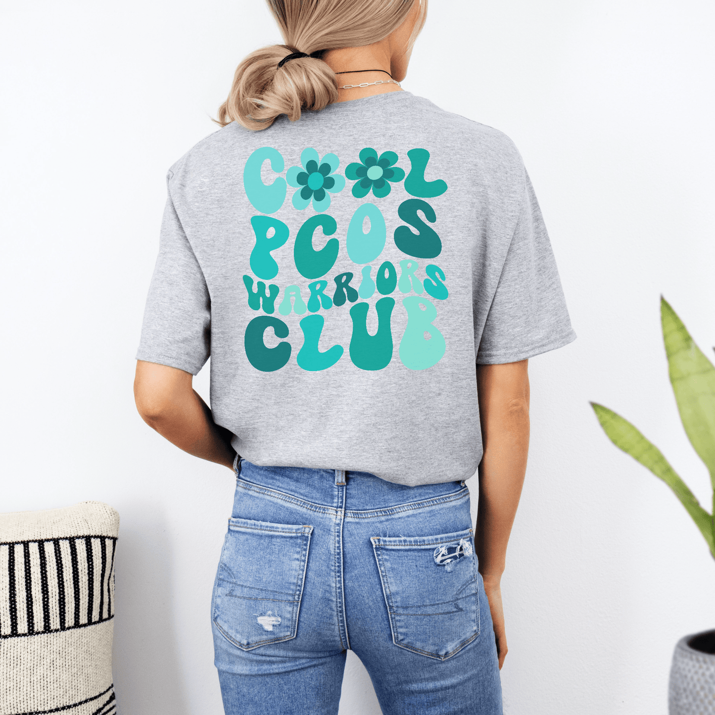 Back view of woman wearing gray PCOS Awareness Shirt with teal Cool PCOS Warriors Club design by Maddy and George Designs