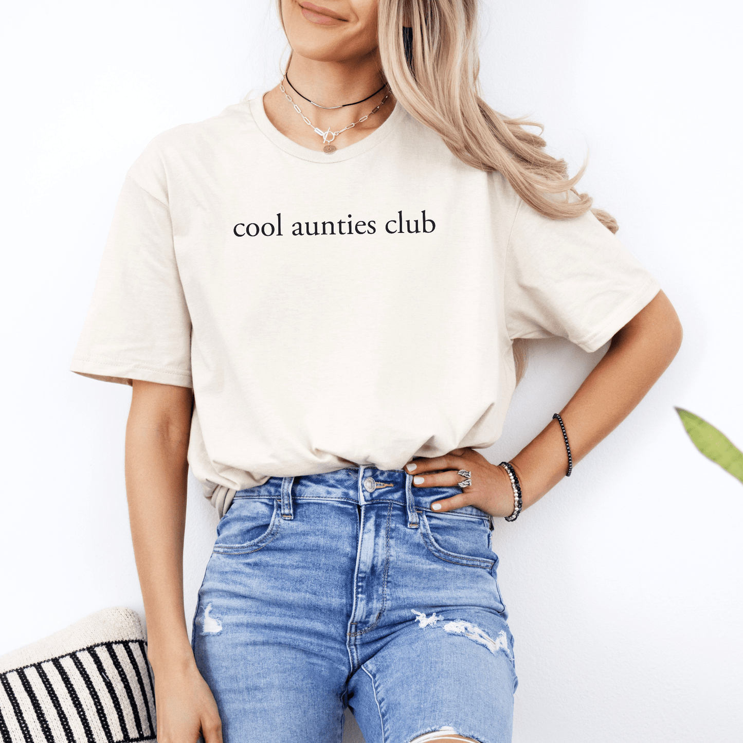 Cream t shirt mockup with cool aunties club text on smiling model wearing denim ideal for New Auntie Pregnancy Announcement Gift