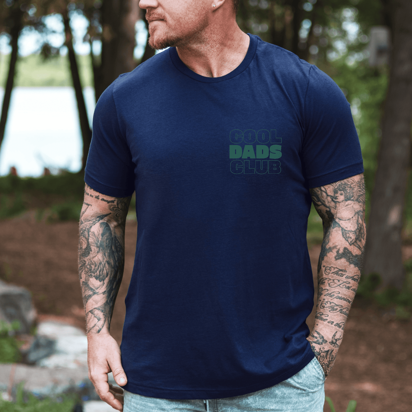 Maddy and George Designs navy tee worn by tattooed man by a lake Cool Dads Club Shirt | New Dad Gift