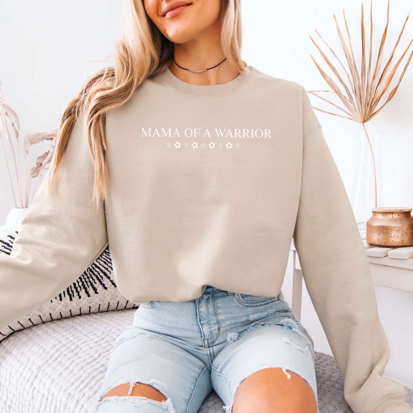 Model wearing beige Mama of a Warrior Sweatshirt with star design casual loungewear look with ripped jeans