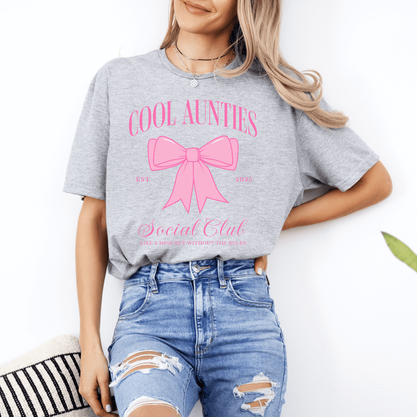 Model wearing Maddy and George Designs Custom Cool Aunties Club Shirt gray tee with pink bow design