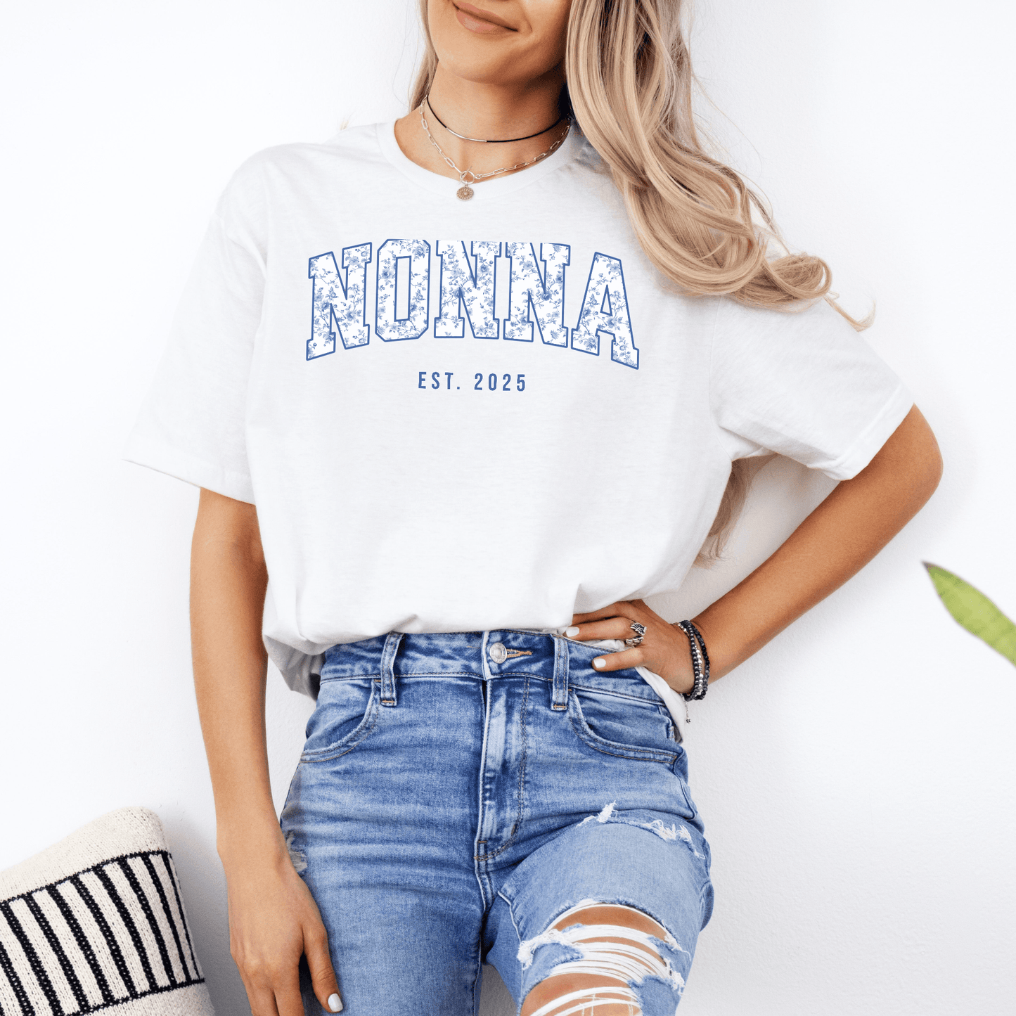 Model wearing white tee with blue distressed NONNA and EST. 2025 print paired with ripped jeans Custom Nonna Est. Year Shirt
