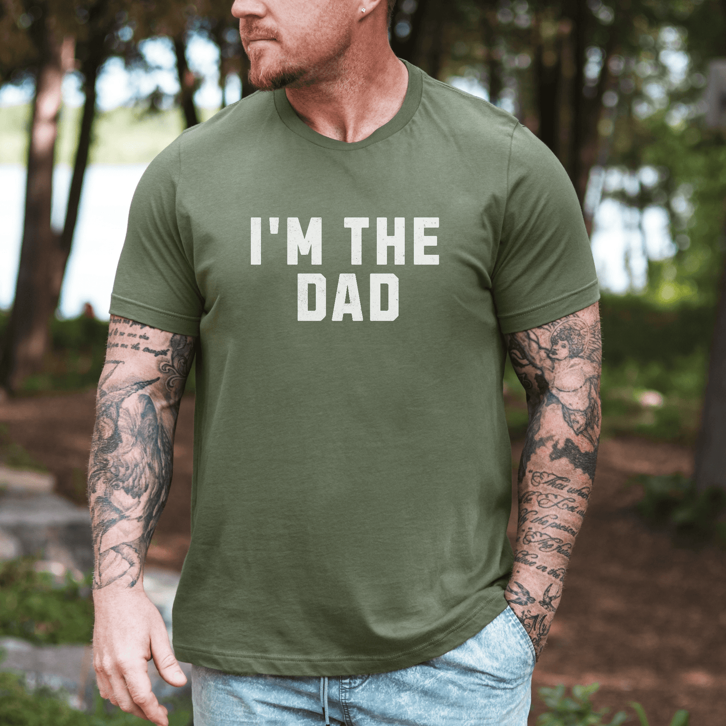 Maddy and George Designs I'm The Dad Shirt olive green crew neck tee with white text worn by tattooed man outdoors
