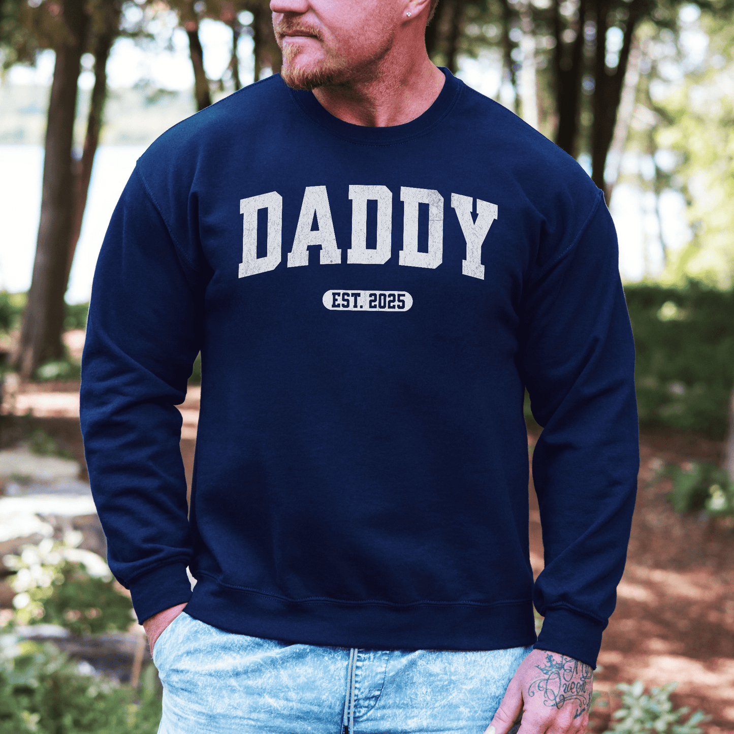 Daddy Sweatshirt with Custom Year navy crewneck worn by man outdoors showing DADDY and est 2025 collegiate print