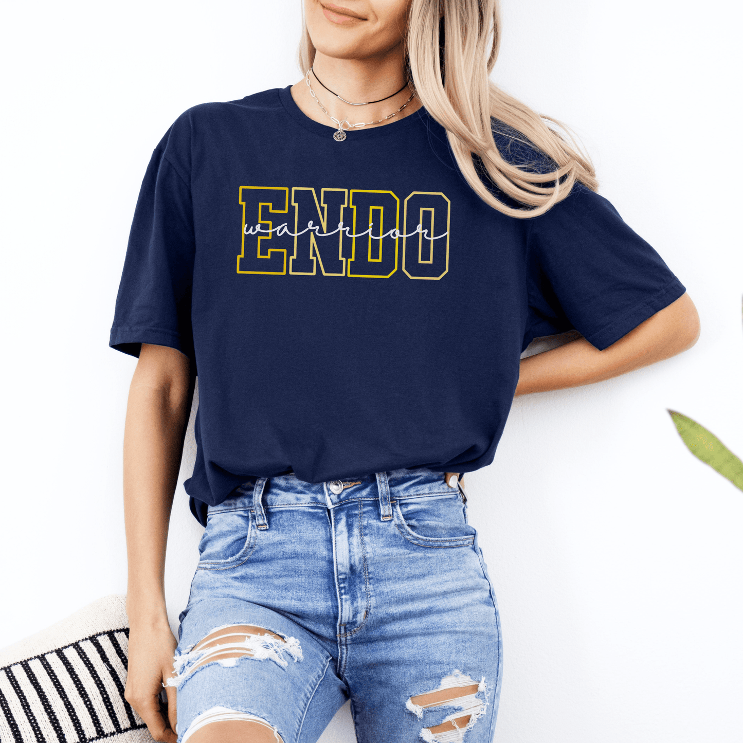 Woman wearing navy Endometriosis Awareness Shirt | Gift For Endo Warrior with bold collegiate ENDO print and distressed jeans