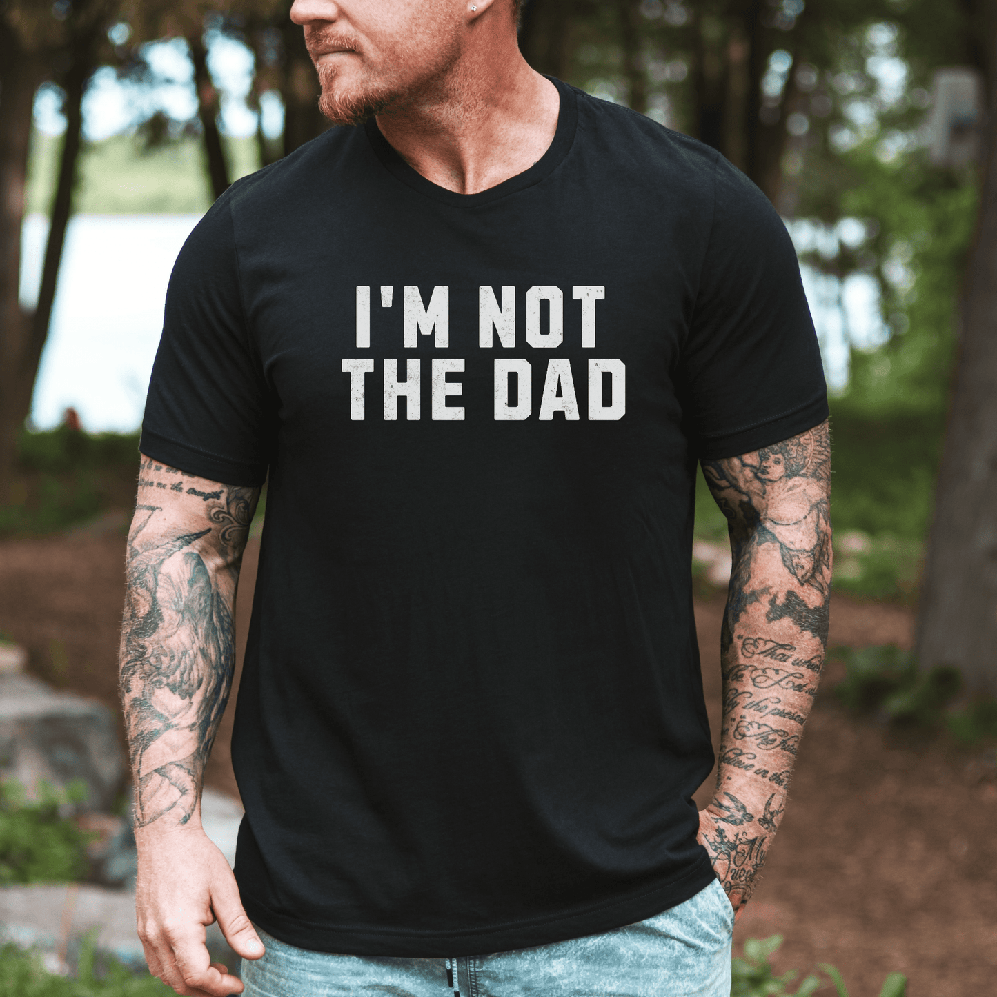 Man wearing black graphic tee with white text tattooed arms outdoor scene funny I'm not the dad shirt