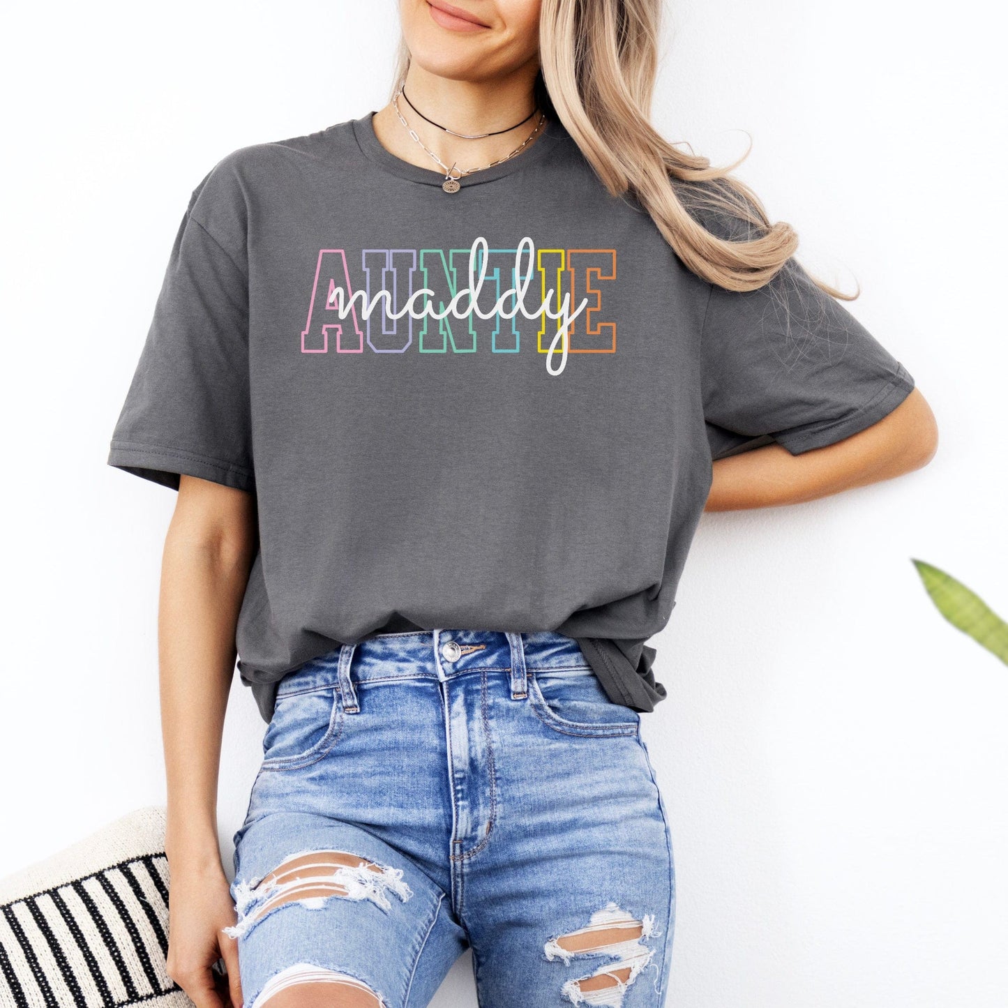 Woman wearing Custom Auntie Shirt gray oversized tee with rainbow outlined AUNTIE and script name paired with ripped jeans