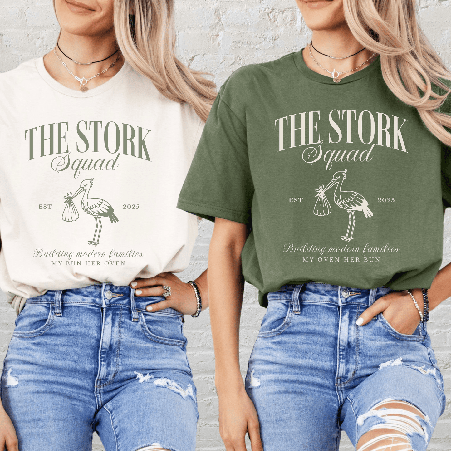 Two women wearing Matching Surrogacy Announcement Tee The Stork Squad print in cream and olive with distressed jeans