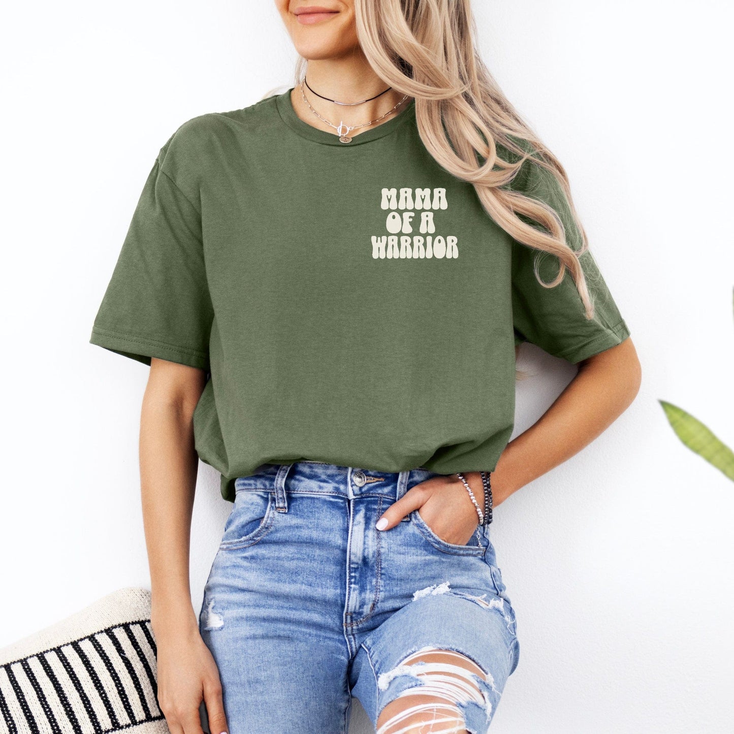 Olive green Mama of a Warrior Club Shirt by Maddy and George Designs worn by woman styled with ripped jeans