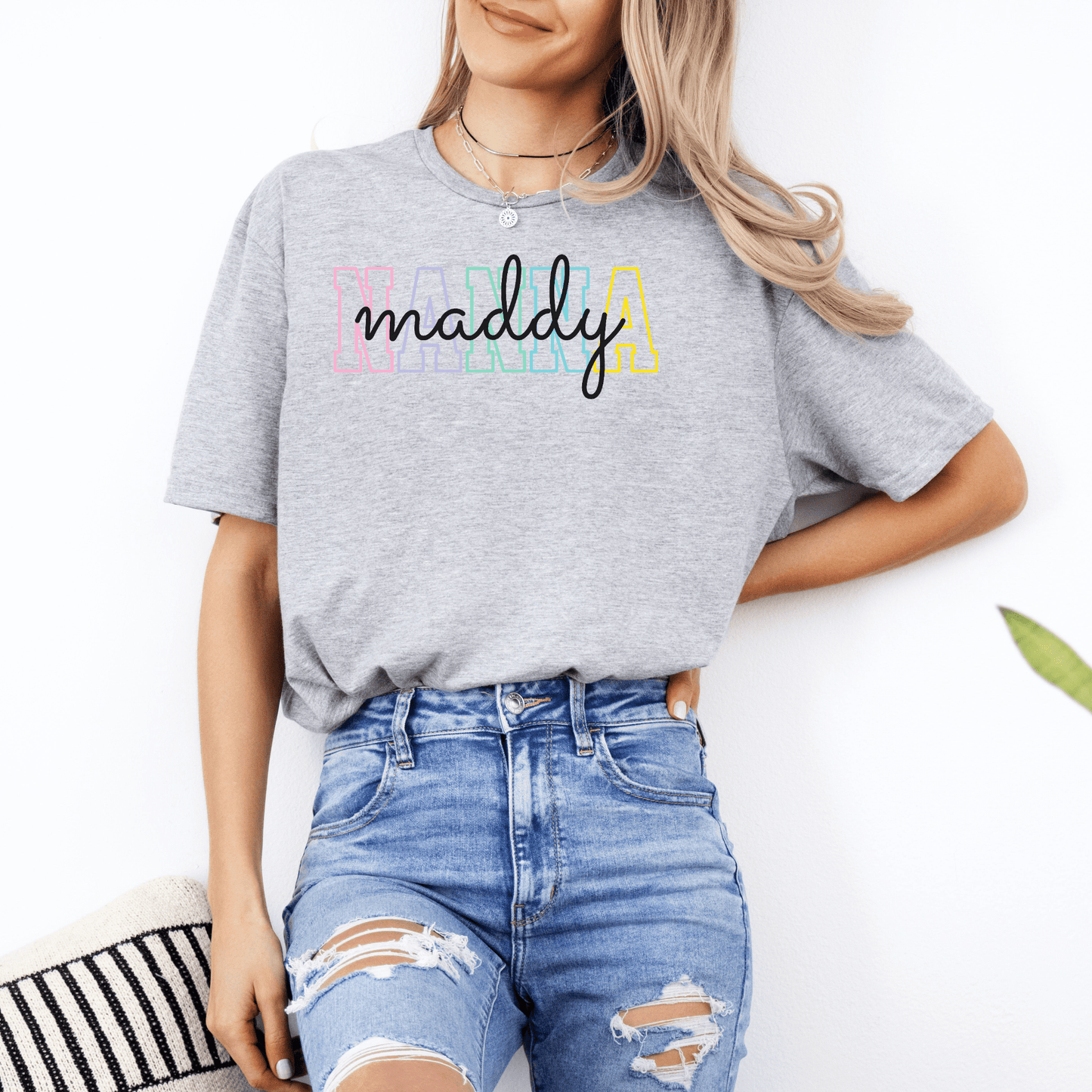 Female model wearing gray Custom Nanna T-Shirt . with colorful maddy name print and ripped blue jeans