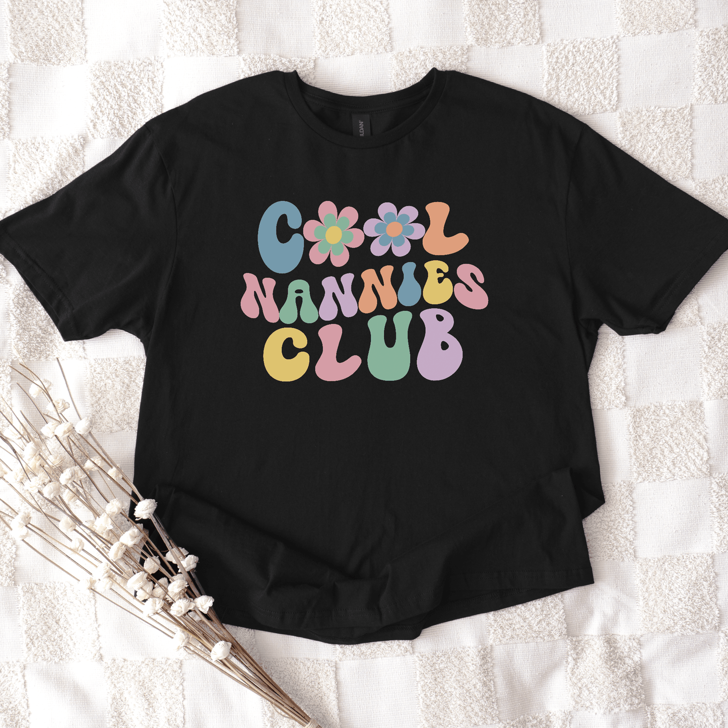 Cool Nannies Club Shirt by Maddy and George Designs black tee with retro pastel bubble letters and flower graphics