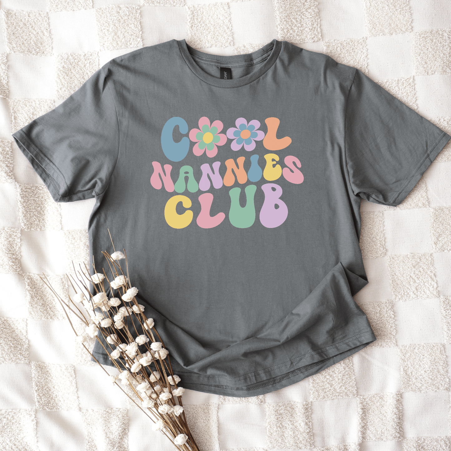 Gray crew neck shirt by Maddy and George Designs with retro pastel bubble text and flowers reading Cool Nannies Club Shirt