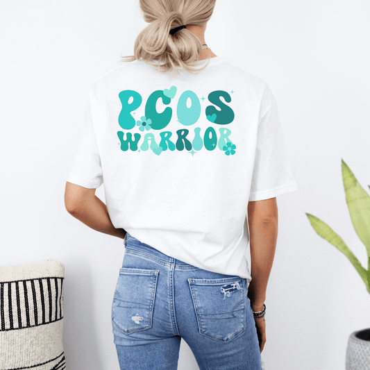Polycystic Ovary Syndrome Awareness Shirt white tee with teal PCOS Warrior graphic on back worn with jeans