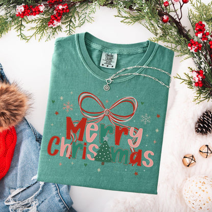 Preppy Merry Christmas Shirt green folded tee with bow and tree graphic and pendant necklace styled with winter props