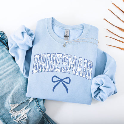 Chinoiserie Bridesmaid Sweatshirt Maddy and George Designs light blue folded crewneck with floral BRIDESMAID print and bow graphic
