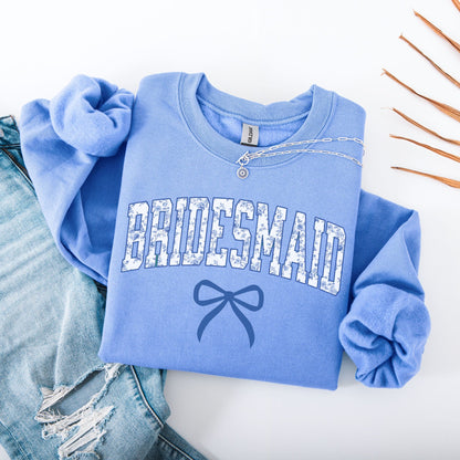 Chinoiserie Bridesmaid Sweatshirt folded light blue with patterned BRIDESMAID letters bow graphic and jeans