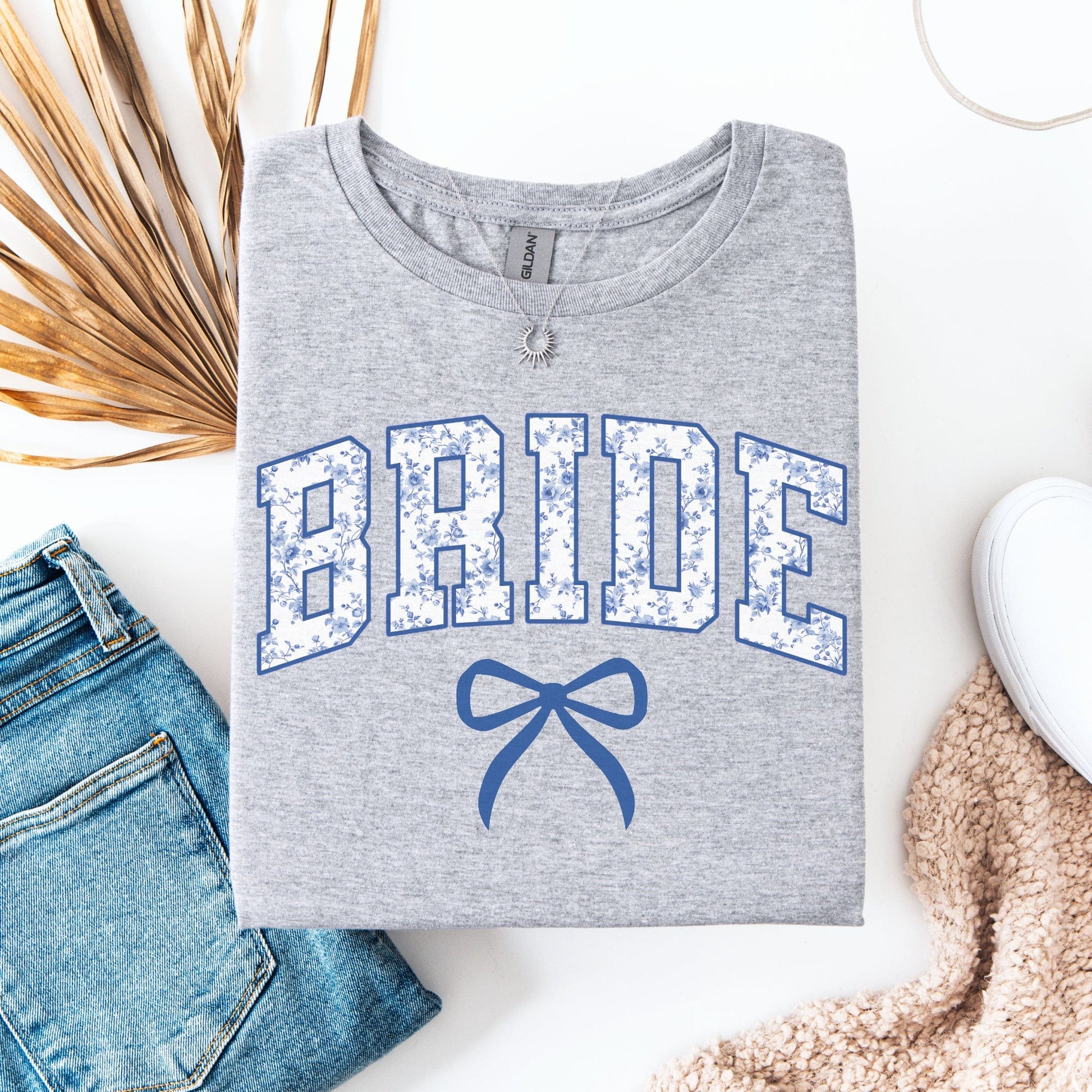 Chinoiserie Bride T-Shirt folded gray tee with blue floral BRIDE lettering and bow, styled with jeans
