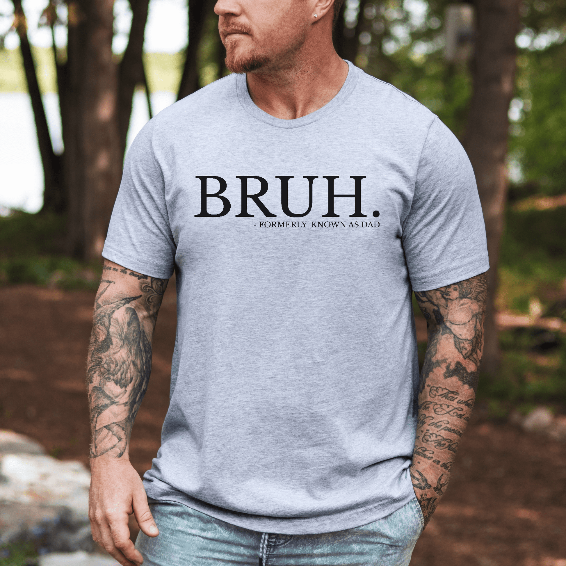Male model wearing gray BRUH Formally Known As Dad Shirt . casual outdoor fit with tattooed arms
