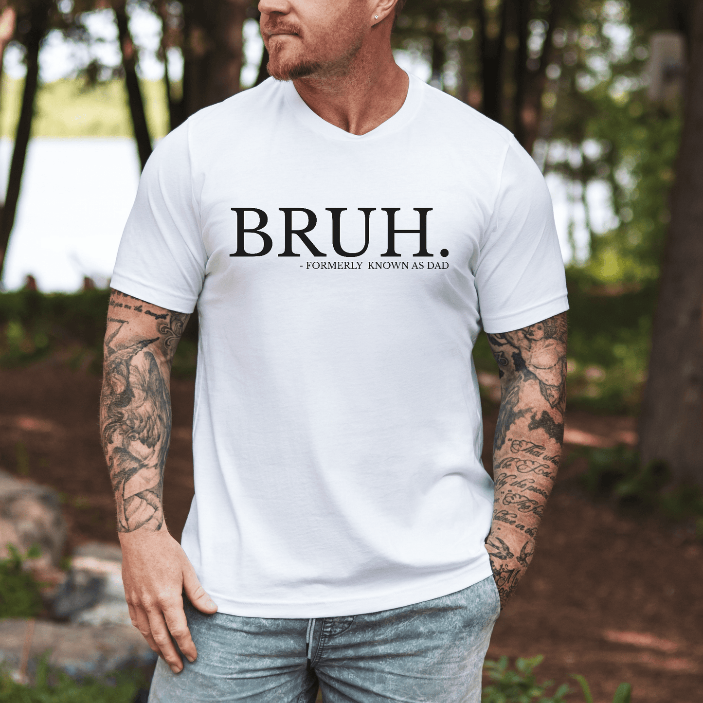 Male model wearing white BRUH Formally Known As Dad Shirt printed on chest casual outdoors