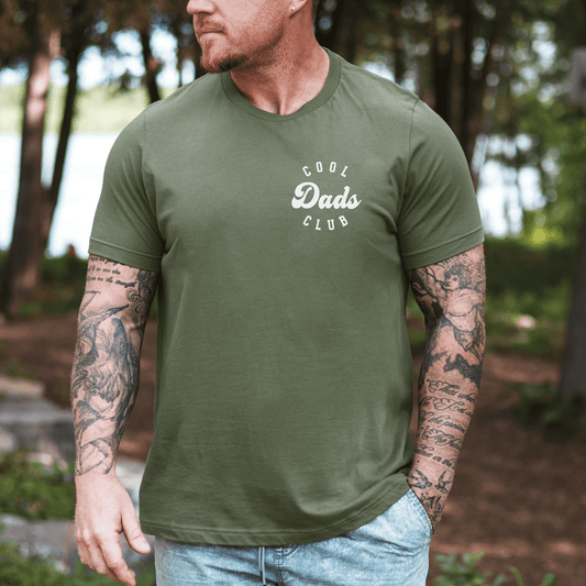 Maddy and George Designs Cool Dads Club Shirt on tattooed man wearing olive green tee outdoors