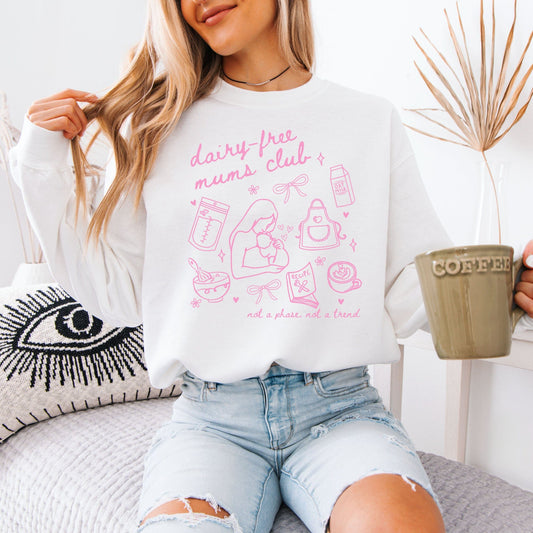 Dairy Free Mums Club Sweatshirt . White sweatshirt with pink breastfeeding line art print worn by woman holding coffee mug