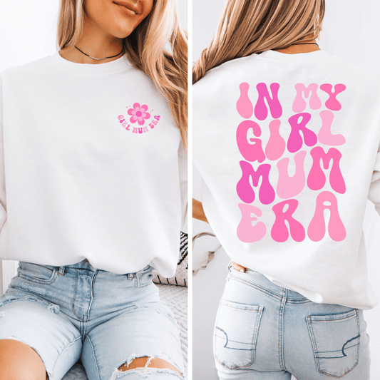 Woman wearing white sweatshirt with small pink flower on chest and bold retro bubble back print In My Girl Mum Era Sweatshirt