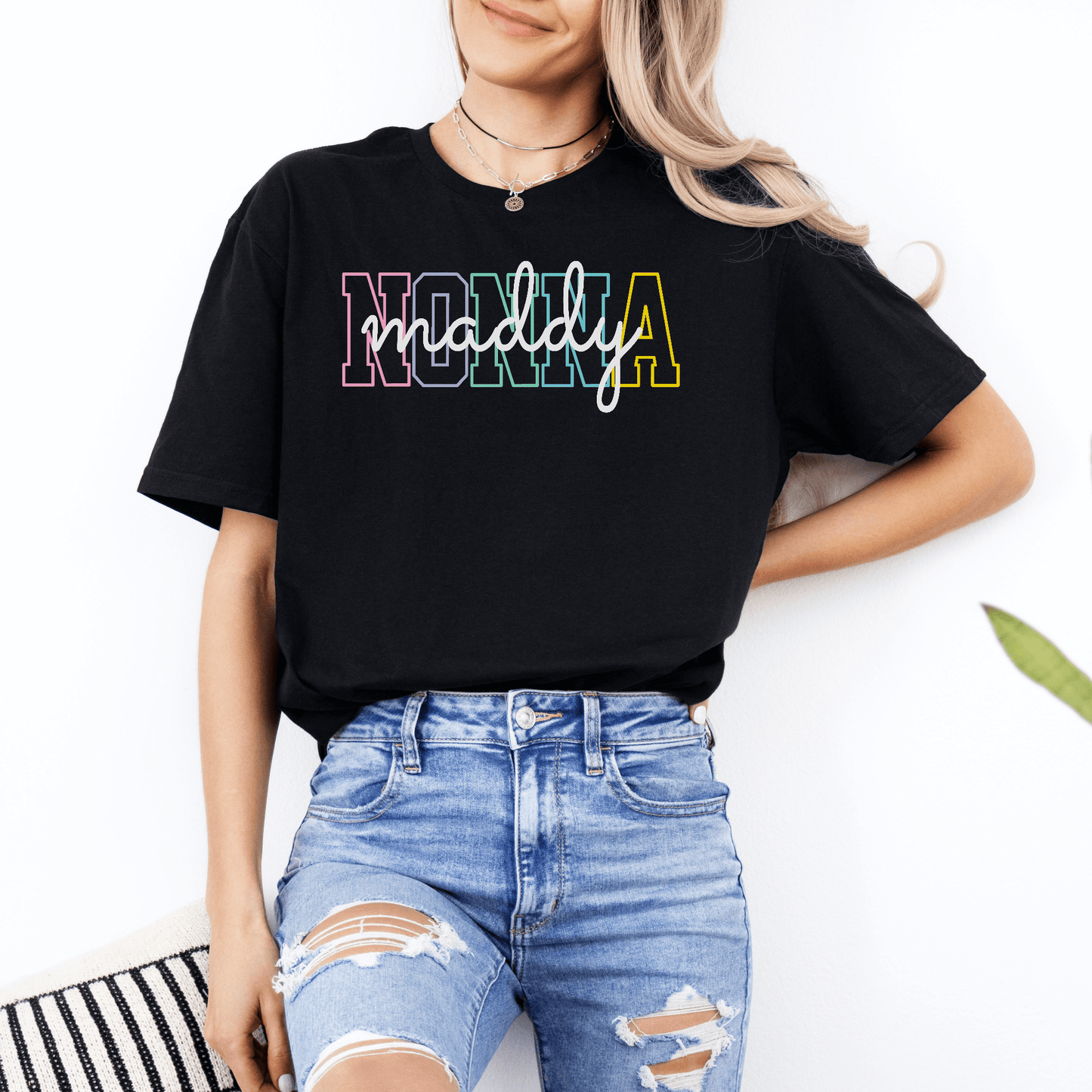 Model wearing black tee with multicolor outlined NONNA and cursive Maddy name Custom Nonna Shirt