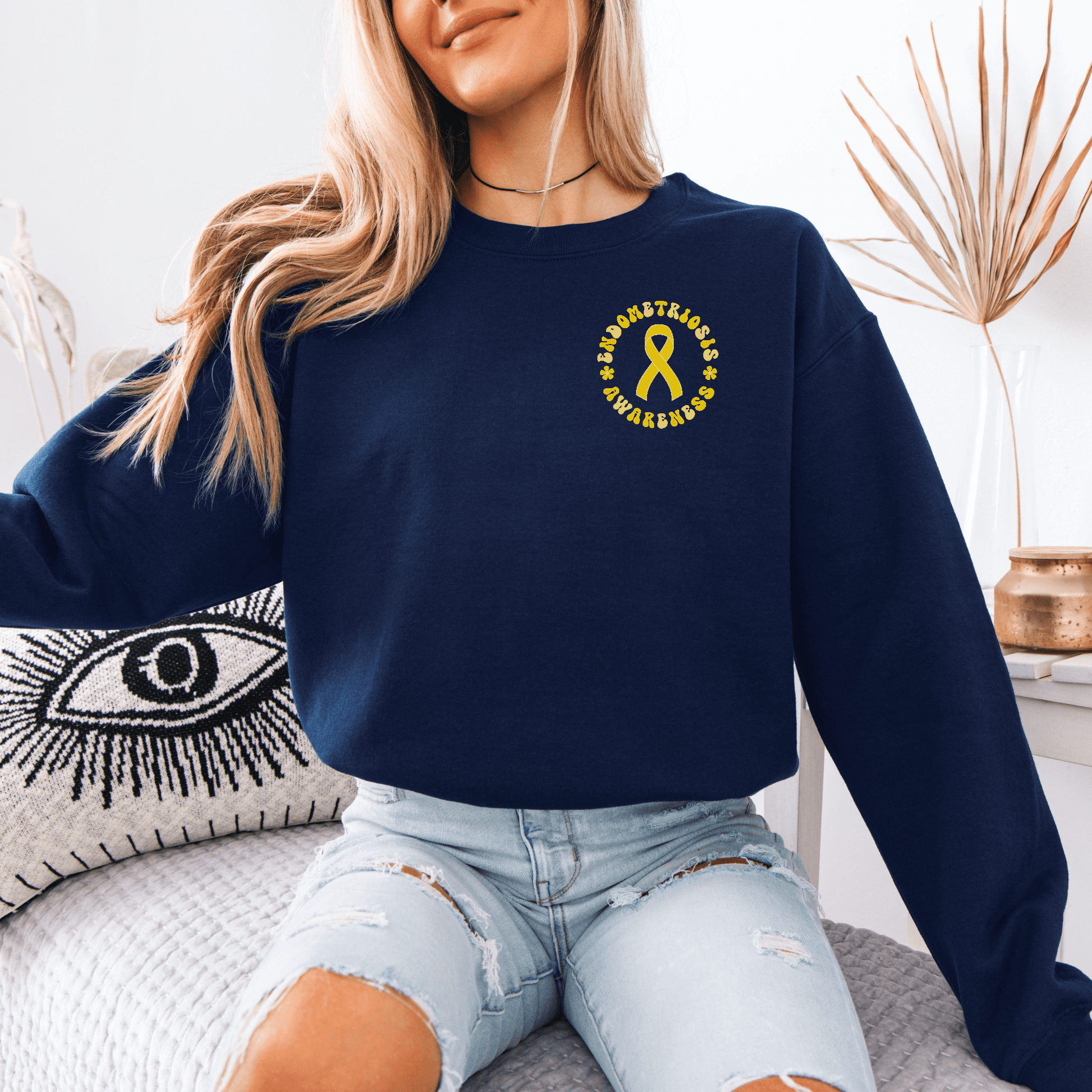 Model wearing navy Endometriosis Awareness Sweatshirt with small yellow ribbon logo left chest by Maddy and George Designs