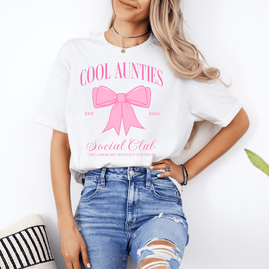 Model wearing Custom Cool Aunties Club Shirt white tee with pink bow graphic and social club print styled with ripped jeans