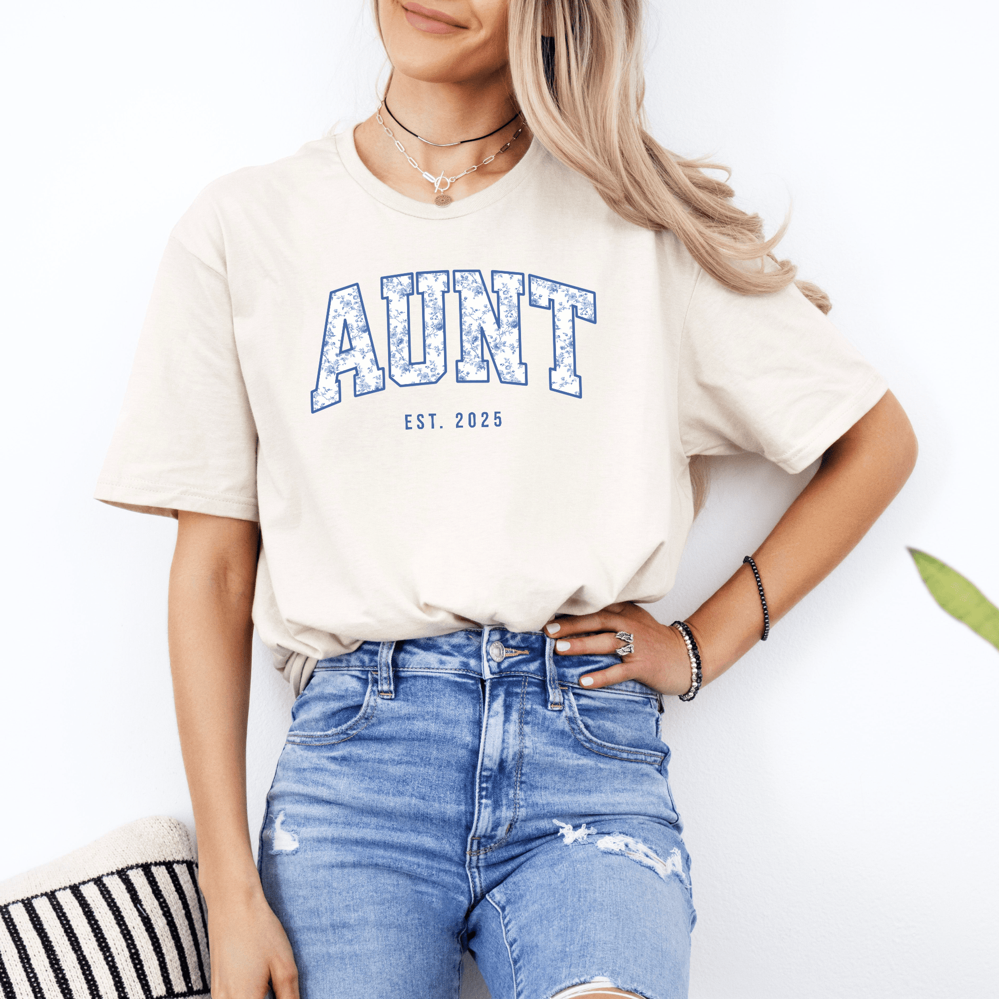 Young woman modeling beige AUNT tee tucked into ripped jeans for everyday style Custom Nonna Est. Year Shirt