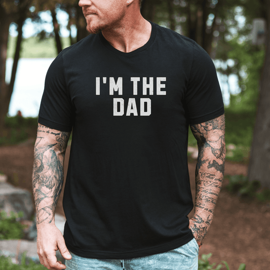 Maddy and George Designs I'm The Dad Shirt black tee on tattooed man by lake for casual wear