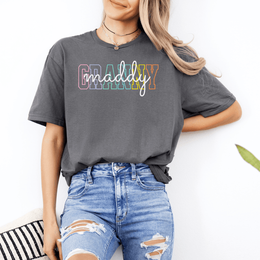 Woman wearing gray tee with rainbow outlined granny text and script design by Maddy and George Designs Custom Granny Shirt