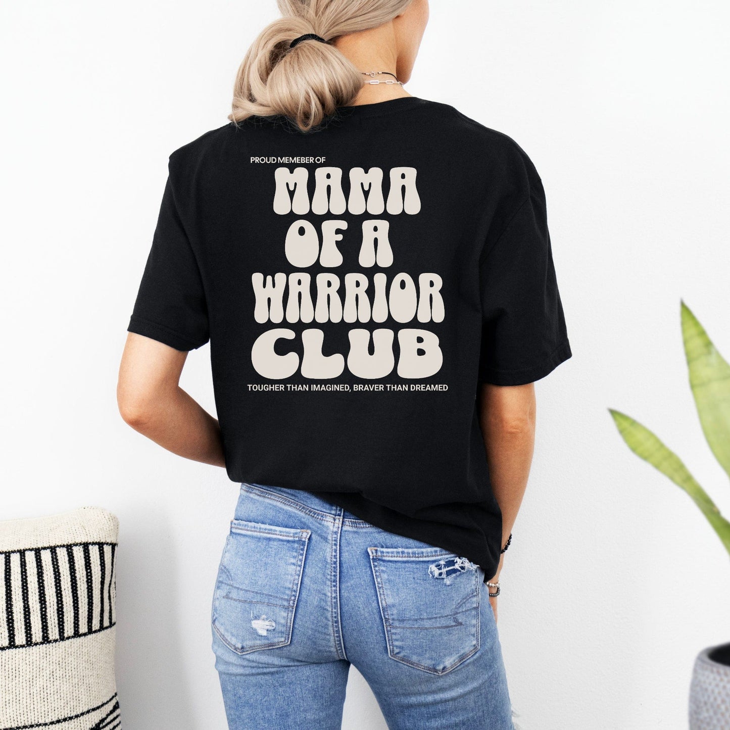Mama of a Warrior Club Shirt black unisex tee shown on woman from back with bold cream text design by Maddy and George Designs