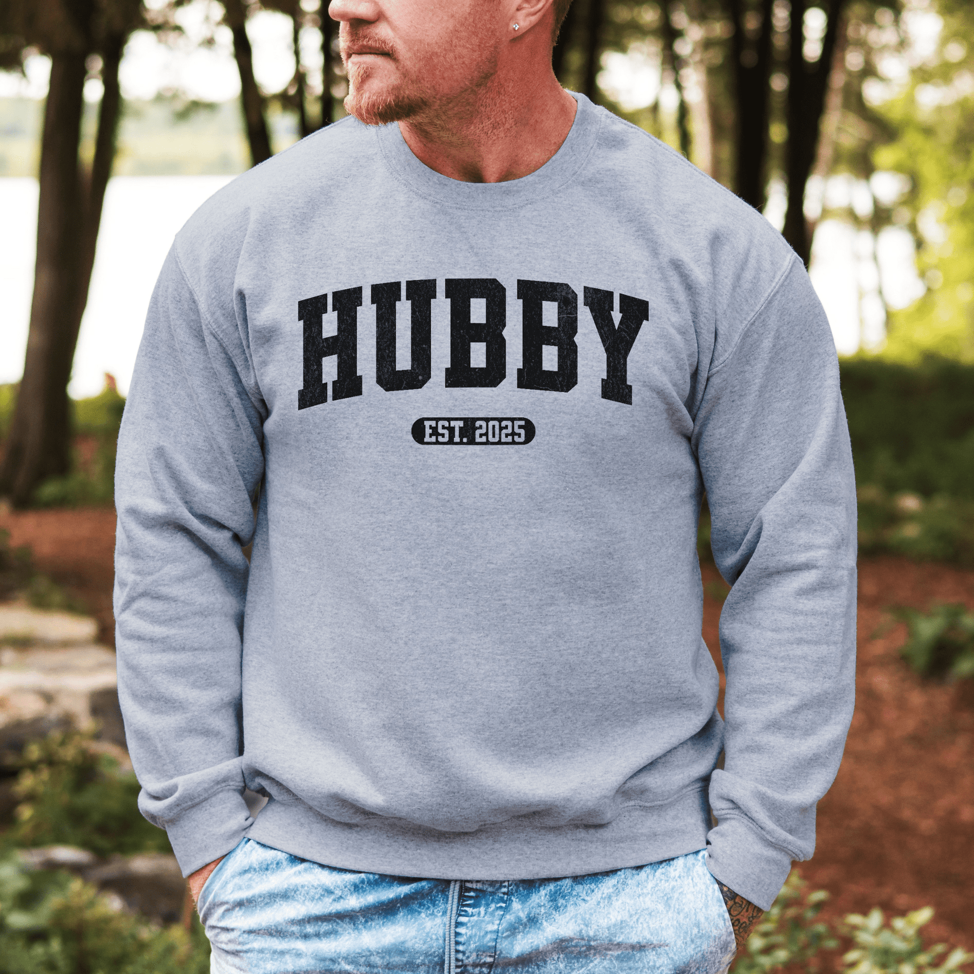 Man wearing gray Custom Hubby EST Year Sweatshirt with bold black HUBBY print casual outdoor setting