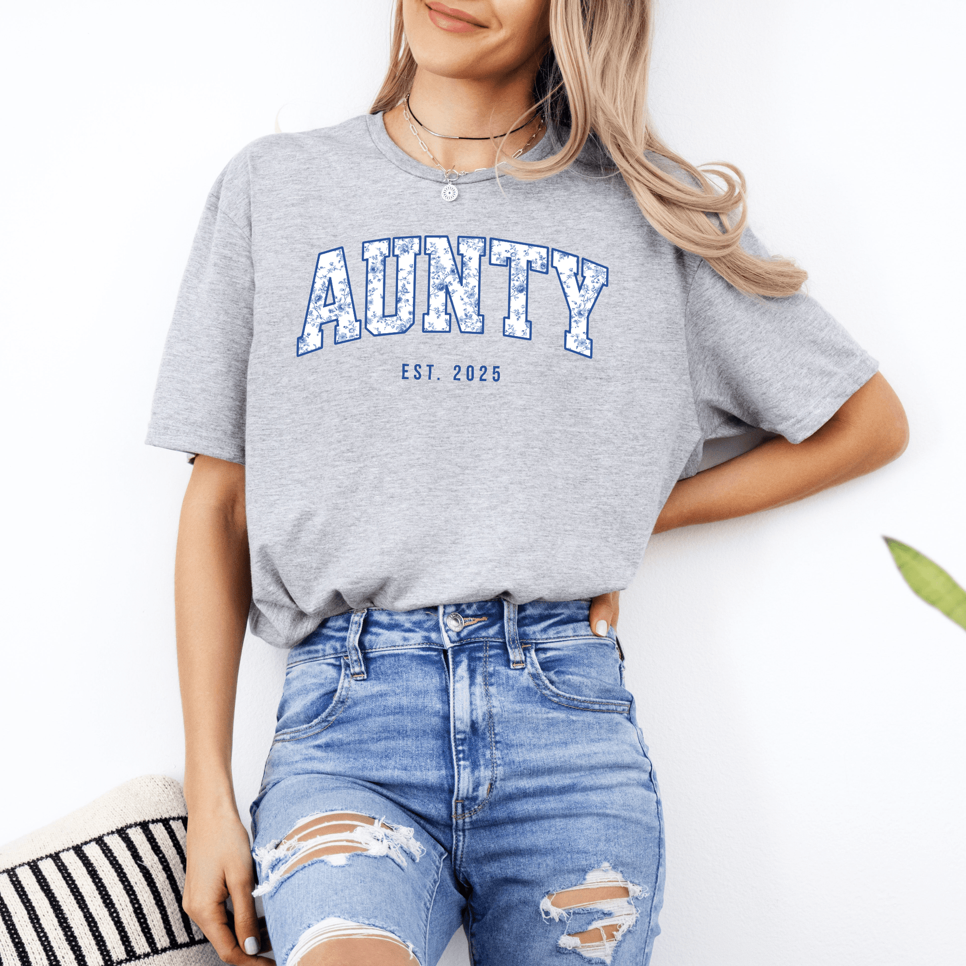 Woman wearing grey Custom Aunty Est. Year Shirt . with blue varsity AUNTY print and distressed jeans casual outfit