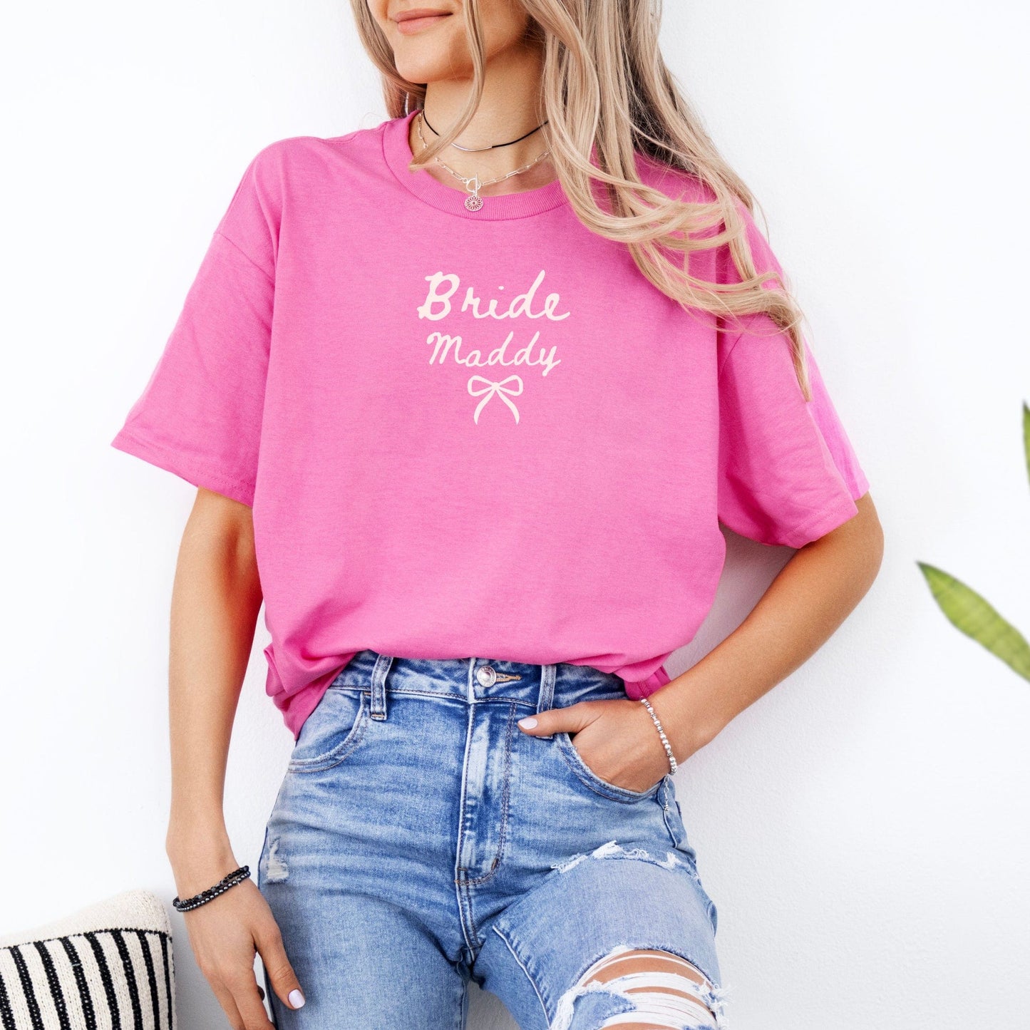 Woman wearing pink Custom Bride T-Shirt by Maddy and George Designs with name Maddy and bow detail