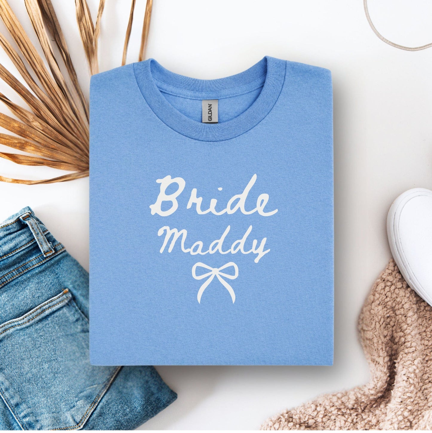 Custom Bride T-Shirt light blue folded tee with white handwritten Bride Maddy print and bow