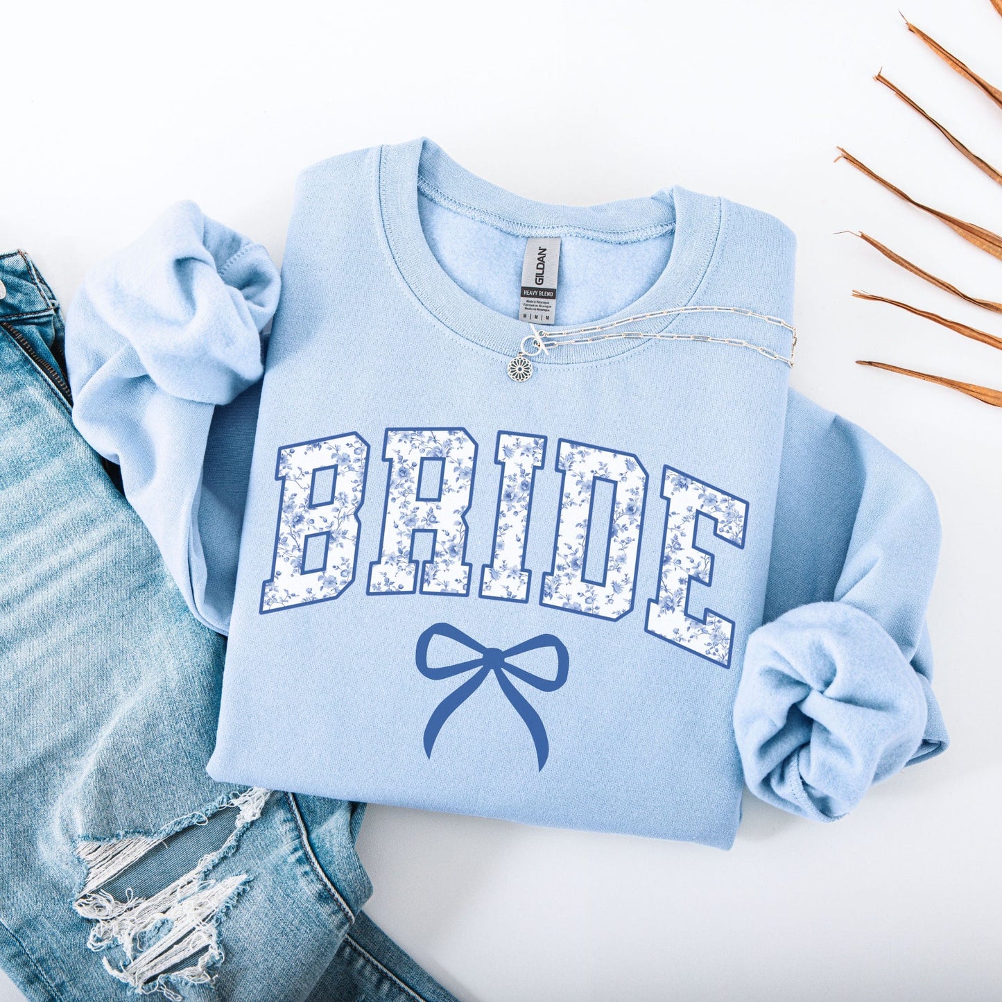Light blue Chinoiserie Bride Sweatshirt with floral patterned BRIDE letters and bow graphic styled with jeans