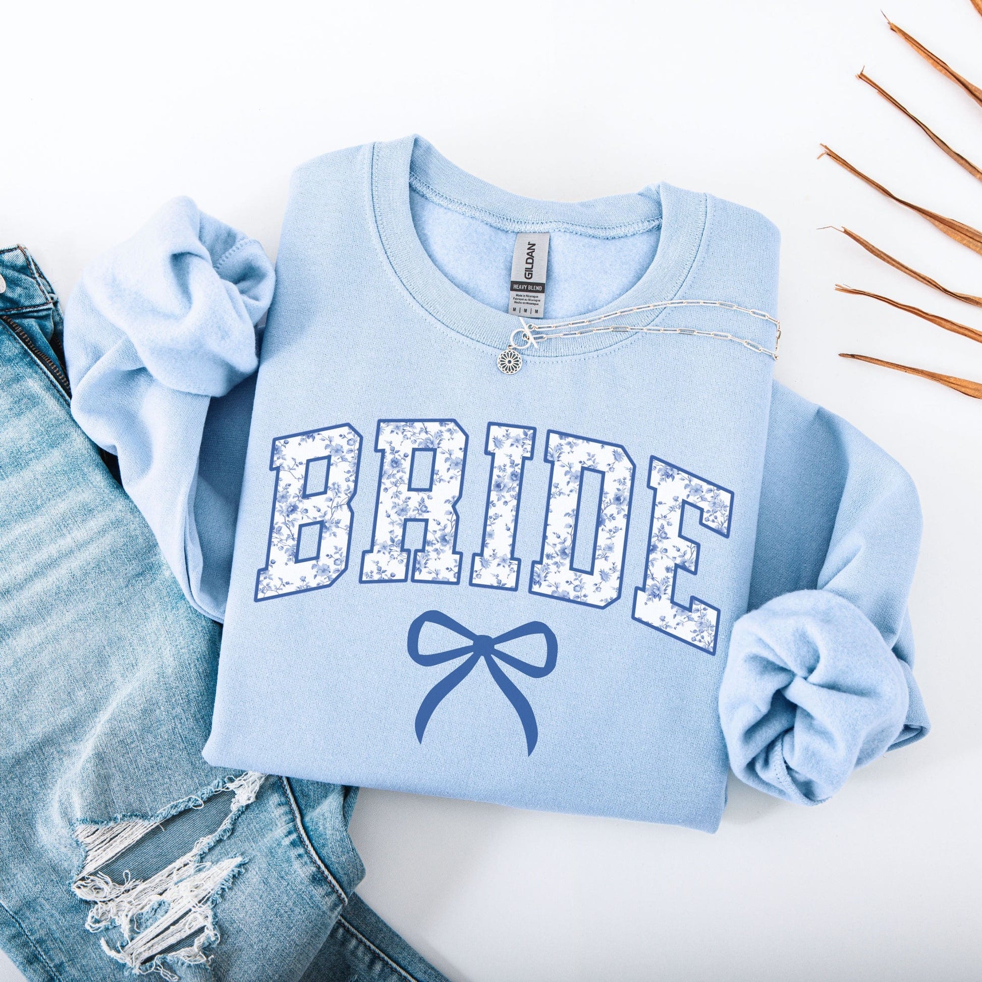 Light blue Chinoiserie Bride Sweatshirt with floral patterned BRIDE letters and bow graphic styled with jeans