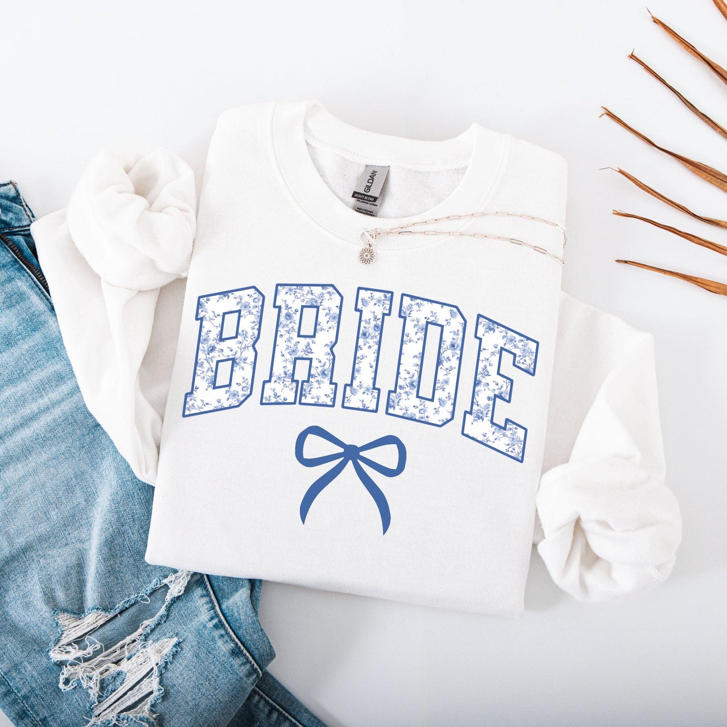 Chinoiserie Bride Sweatshirt white folded with blue floral BRIDE lettering and bow design by Maddy and George Designs